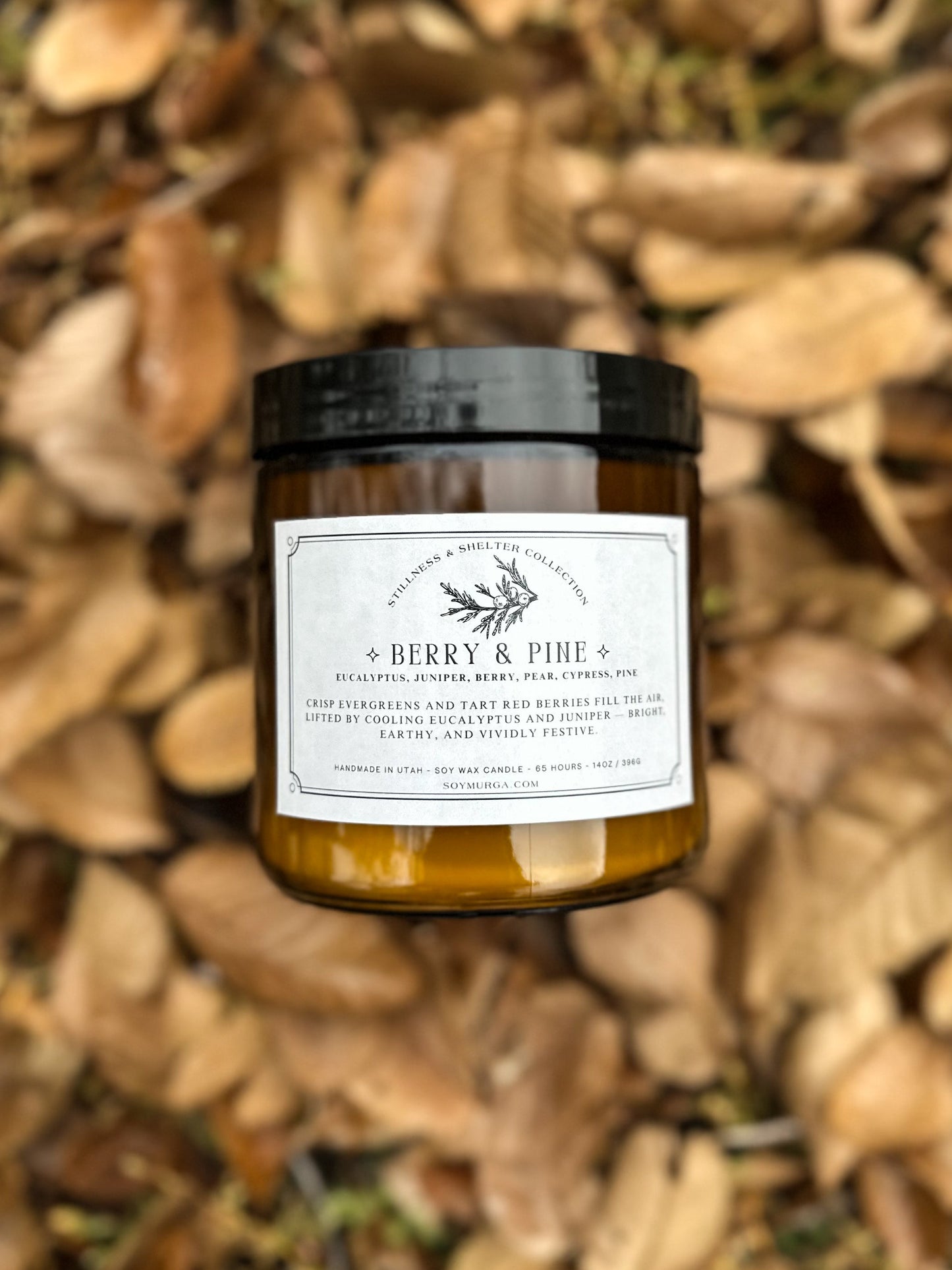 Jar of 'Berry & Pine' candle on a leafy background